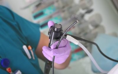 Close-up of a gloved hand holding the control handle of an endoscope