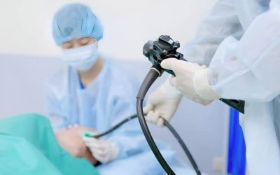 Close-up of clinicians' gloved hands holding an endoscope during a procedure